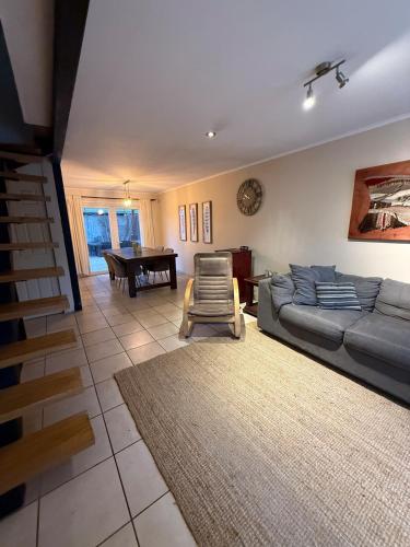 un soggiorno con un divano e un tavolo di Casa para 6 en Villarrica Jardín Floresta a Villarrica