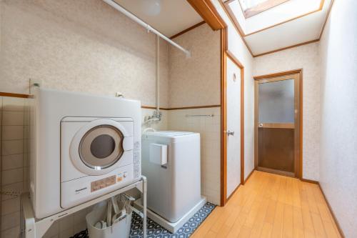 a bathroom with a washer and dryer in it at GUEST HOUSE Hotori 2nd in Otsu