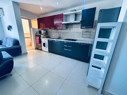 eine Küche mit blauen Schränken und einer Treppe darin in der Unterkunft Appartement vue sur la mer Almadies Dakar "Résidence les embruns" in Dakar