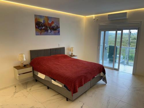 a bedroom with a bed with a red comforter at Casa completa para relaxar com a família in Passo De Torres