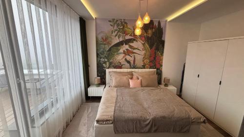 a bedroom with a bed with a painting on the wall at C-Home in Pécs
