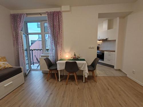 Star Apartments Brno C33# by Starbnb EU في برنو: غرفة معيشة مع طاولة وكراسي ومطبخ