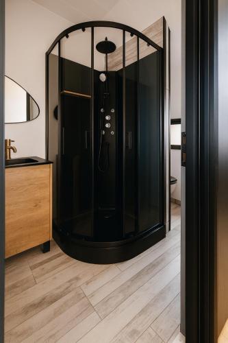 a glass shower in a room with a wooden floor at Canal apartment ! Close to USON & Pont de Loire Nevers in Nevers