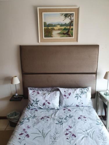 a bedroom with a bed with a picture on the wall at The Manse in Port Shepstone