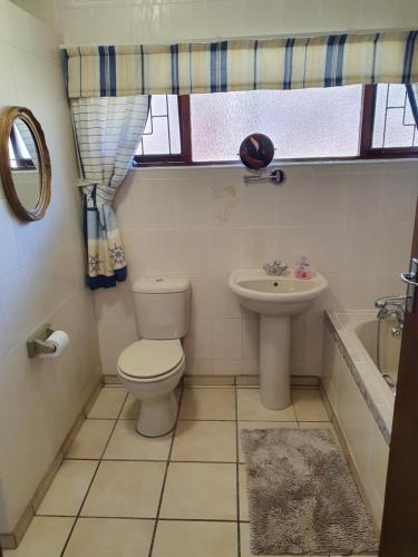 a bathroom with a toilet and a sink at The Manse in Port Shepstone