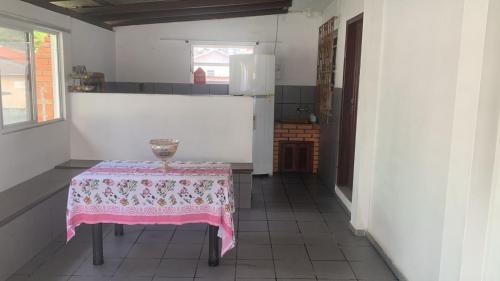 a kitchen with a table with a pink table cloth on it at Pousada da Magia in Florianópolis