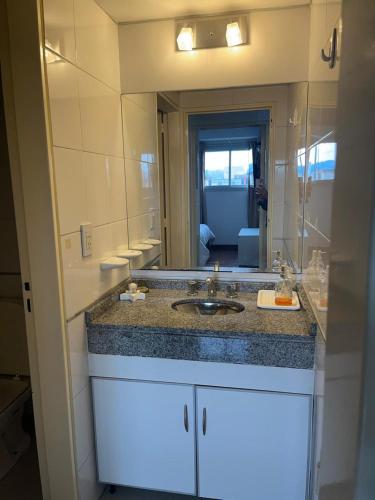 Un baño con lavabo y un espejo grande. en Departamento Andy, en Villa Carlos Paz