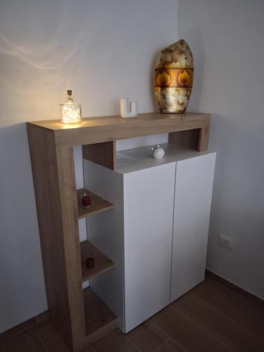 ein Holzregal mit einer Vase darüber in der Unterkunft A Casa di Lucia-Appartamento Deluxe in Piedimonte San Germano