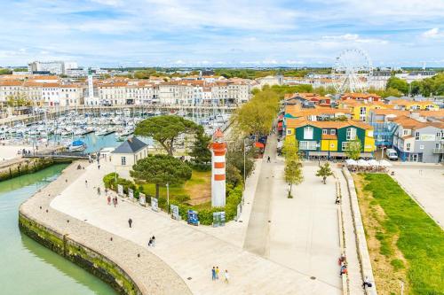 vue d'une ville avec un phare et un port dans l'établissement Séjour prestige - vue mer et accès privé à l'océan, à Angoulins-sur-Mer