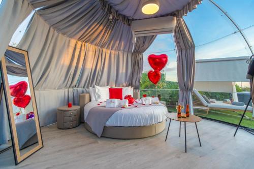 - une chambre avec un lit doté de ballons à cœur rouge dans l'établissement Experiencia Habitación Burbuja con Jacuzzi Privado, Piscina y Vistas al Mar, à Guía de Isora