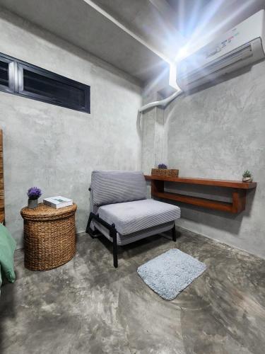 a living room with a chair and a air conditioner at Villa Arcadia in Los Baños