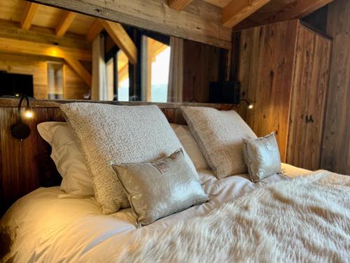 un letto bianco con cuscini sopra di Chalet « Le 1712 » direct pistes a Les Angles