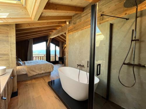 un bagno con vasca e una camera da letto di Chalet « Le 1712 » direct pistes a Les Angles