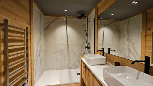 un bagno con due lavandini e un grande specchio di Chalet 4 Saisons ski aux pieds a Les Angles