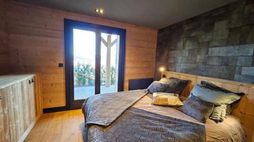 una camera da letto con un letto con una grande finestra di Chalet 4 Saisons ski aux pieds a Les Angles