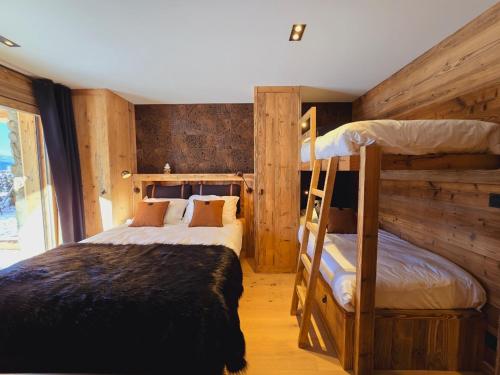 Dos literas en una habitación con paredes de madera. en Chalet Bliss Jacuzzi vue, en Bolquere Pyrenees 2000