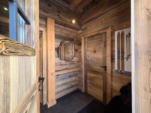 Un pasillo de madera en una cabaña de troncos con una puerta en Chalet Bliss Jacuzzi vue, en Bolquere Pyrenees 2000