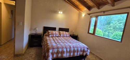 ein Schlafzimmer mit einem Bett und einem großen Fenster in der Unterkunft Valkara Patagonia in Las Golondrinas