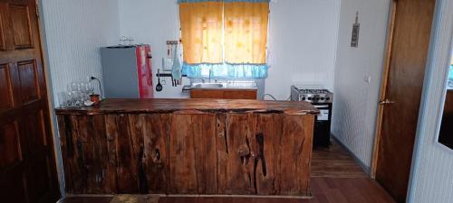 a kitchen with a wooden island in the middle at Cabaña Quemchi in Quemchi