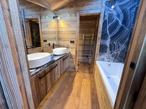 une salle de bain avec deux lavabos et un grand miroir dans l'établissement Chalet Colchiques aux pieds des pistes sauna, à Font-Romeu