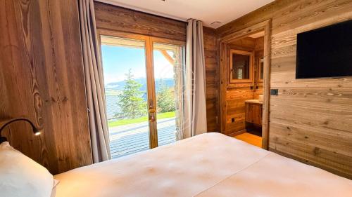 a bedroom with a bed and a large window at Chalet Agane proximité pistes immédiate in Les Angles