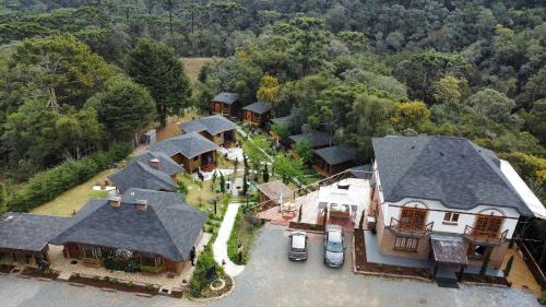 eine Luftansicht eines Hauses mit geparkten Autos in der Unterkunft Pousada Chales da Mantiqueira - Campos do Jordão in Campos do Jordão