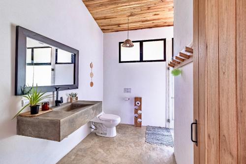 a bathroom with a sink and a toilet at Private rainforest villa up to 8 guests w jacuzzi near Rio Celeste in Upala