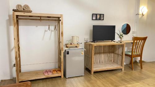 a room with a refrigerator and a desk with a television at A Day Rayong in Ban Pa Khan