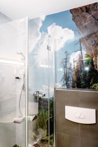 a bathroom with a shower with a painting on the wall at Hotel - Restaurant Goisererhof 3S in Bad Goisern