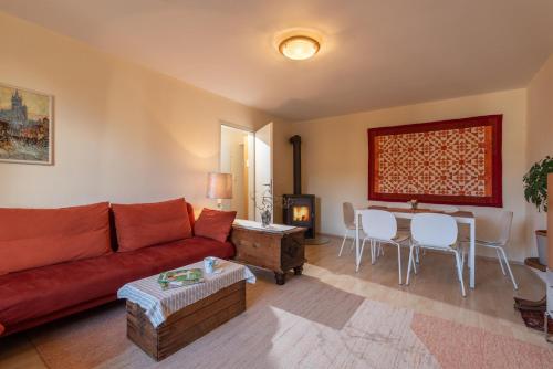a living room with a red couch and a table at Villa Gartenblick in Kufstein