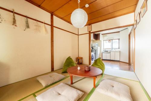 ein Wohnzimmer mit Tisch und Stühlen in der Unterkunft GUEST HOUSE Hotori in Ōtsu
