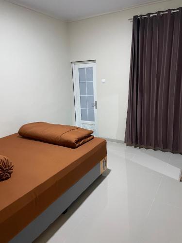 une chambre avec un lit et une fenêtre dans l'établissement Villa nuansa tawangmangu, à Tawangmangu