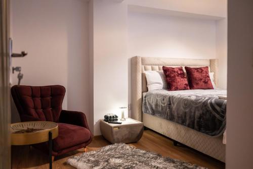 a bedroom with a bed with red pillows and a chair at Apartament de închiriat Accommodation nr 12 in Suceava