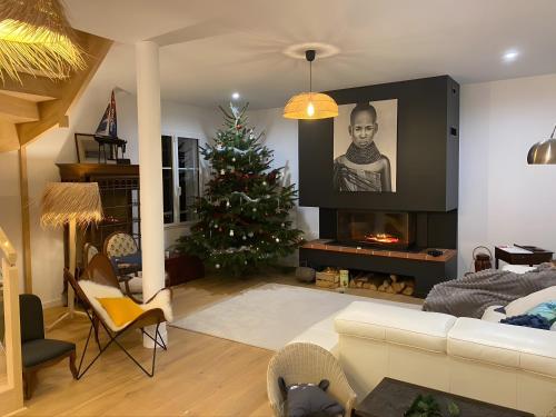 ein Wohnzimmer mit einem Weihnachtsbaum und einem TV in der Unterkunft Ker Anna, 120m De La Plage, Vue Mer in La Terre du Pont