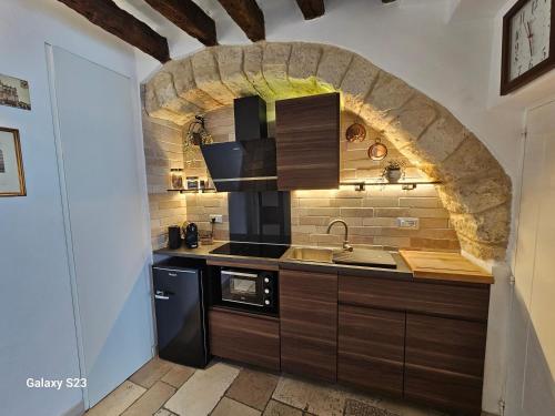 a kitchen with a sink and a brick wall at Le Antiche Travi in Bari