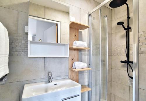 une salle de bain avec lavabo et douche dans l'établissement La Plage du Petit Port, à Cancale