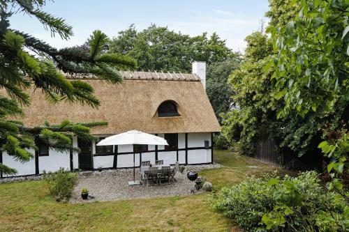 a house with a thatched roof with a patio at 300-Year-Old House With History And Character in Stege