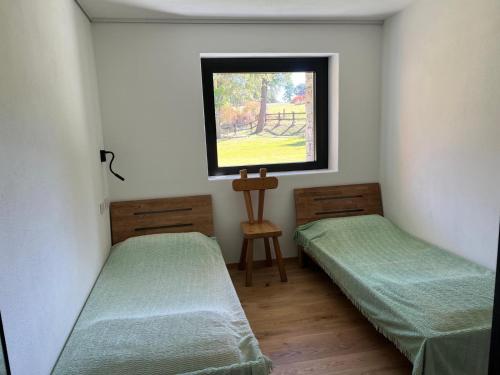 two beds in a room with a window at Casa Luigina in Verrayes