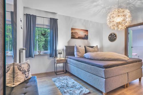 a bedroom with a bed and a chandelier at Ferienwohnungen Geiger in Bodenmais