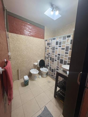 a bathroom with a toilet and a sink at Alojamiento cuyum in Rivadavia