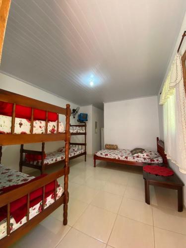 a room with three bunk beds in a room at Pousada Simone Paulista in Paraty