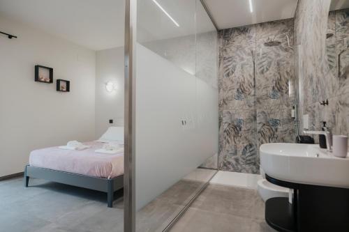 a bathroom with a shower and a bed and a sink at B&B Lilà in Chieti