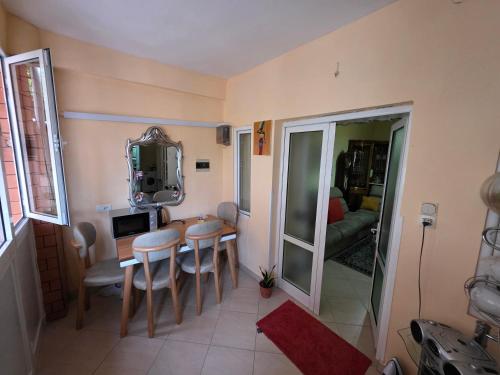 un comedor con una mesa y sillas y un espejo en House 75, en Tirana