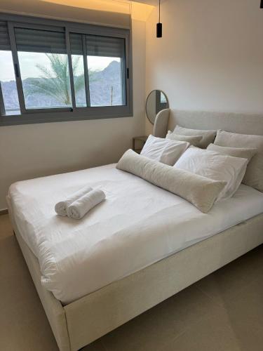 ein weißes Bett mit einem Handtuch darauf in der Unterkunft מילה דירות אירוח - Bnb70 in Eilat