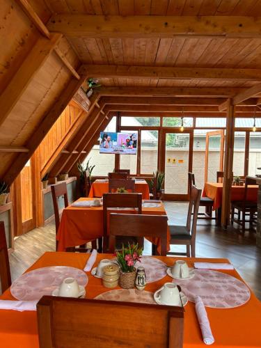a dining room with tables and chairs and a television at Silent Inn Apartments in Arusha