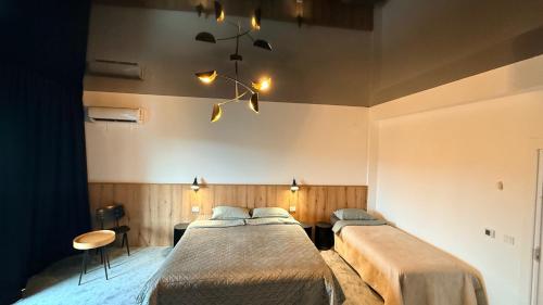 a bedroom with two beds and a chandelier at Cozy Studios Barlad in Bîrlad