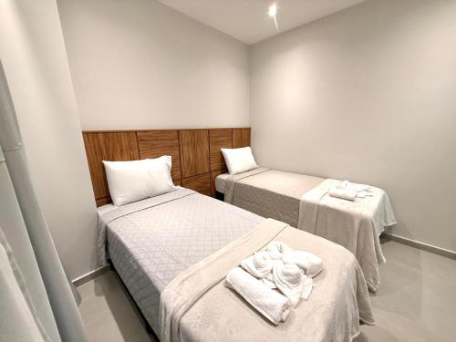 - 2 lits dans une petite chambre avec des serviettes dans l'établissement Apartamento mobiliado Beira-Mar, à Maragogi