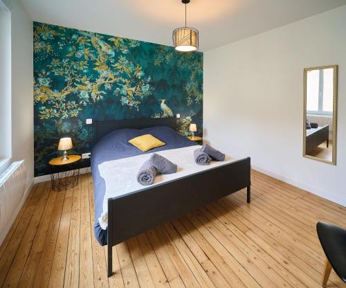 ルマンにあるLe Confort T2 tout équipé, proche Gare, Centre ville, Circuit des 24Hの壁に大きな絵が飾られたベッドのある寝室