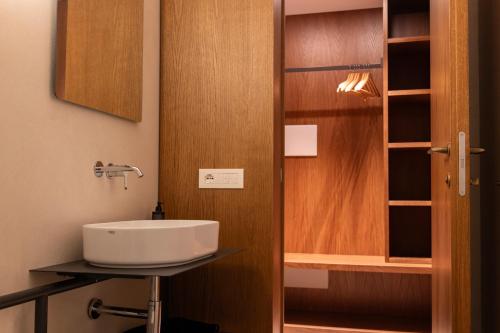 a bathroom with a sink and a wooden door at Dal Console Rooms in Naples
