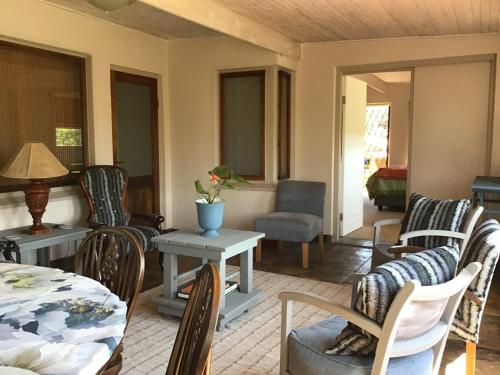 ein Wohnzimmer mit Stühlen und einem Tisch in der Unterkunft Corner View Accommodation in Kaapsehoop